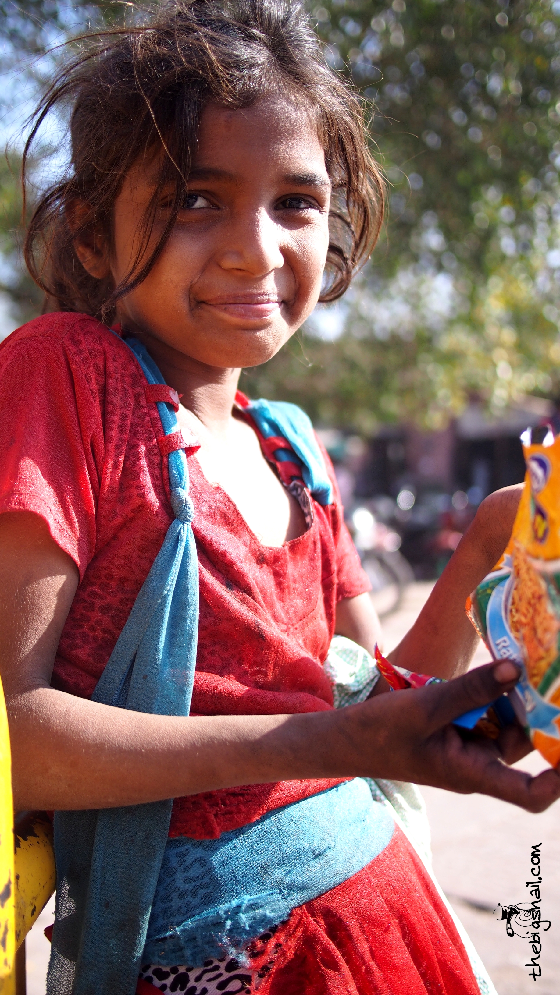 Suman, debout à côté de la barrière jaune, namkin et paan masala dans les mains