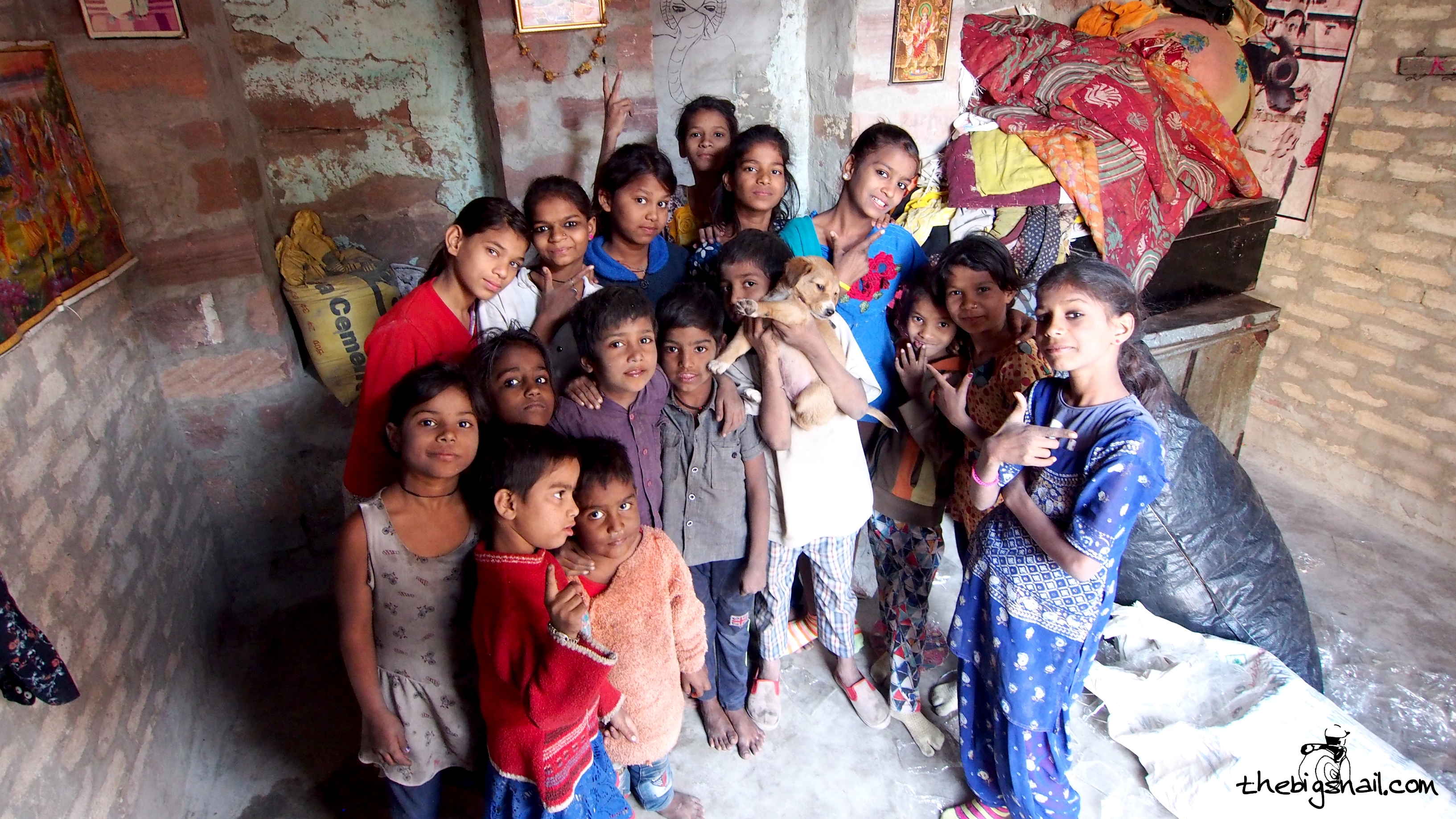 Anjali avec une dizaine de ses sœurs et quatre garçons dans une petite pièce aux murs de brique.